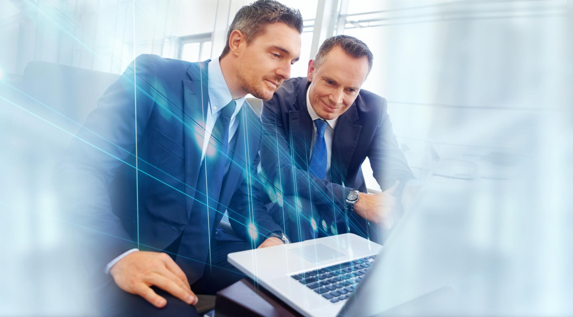 Dois executivos analisando dados em um laptop